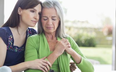 拥抱哀伤的老妇人的少妇