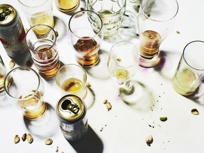 collection of empty glasses and beer cans on table