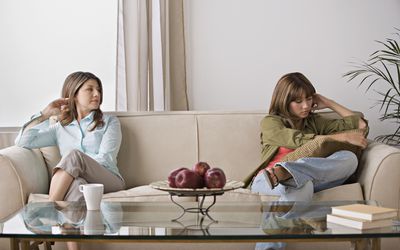 心烦意乱的妇女坐在沙发上的两侧