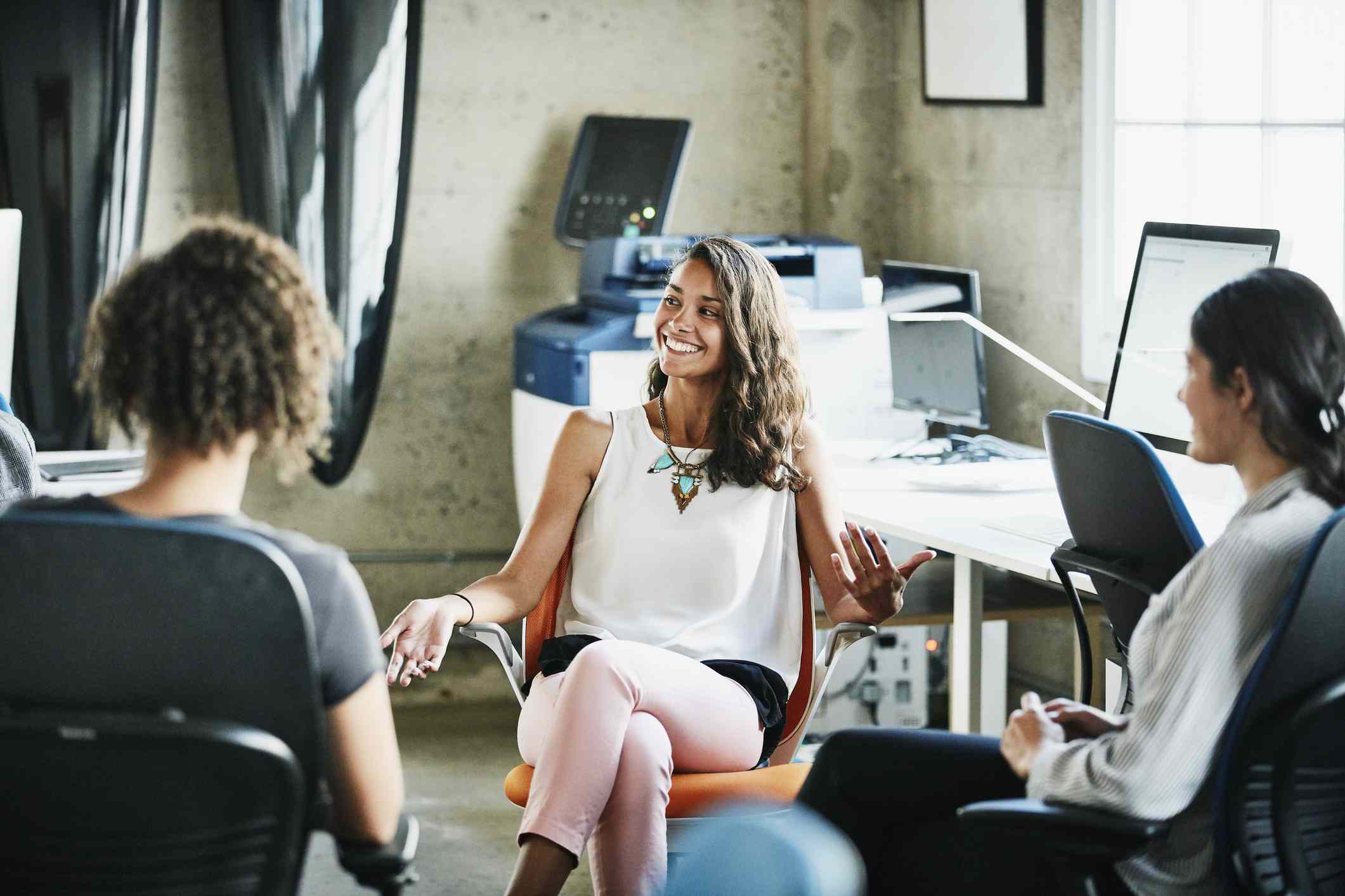 妇女在办公室谈话与她的同事。