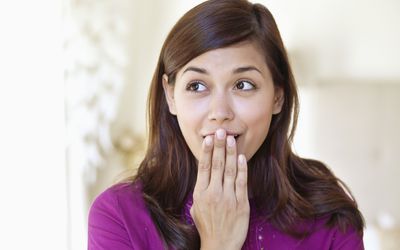 embarrassed woman covering her mouth