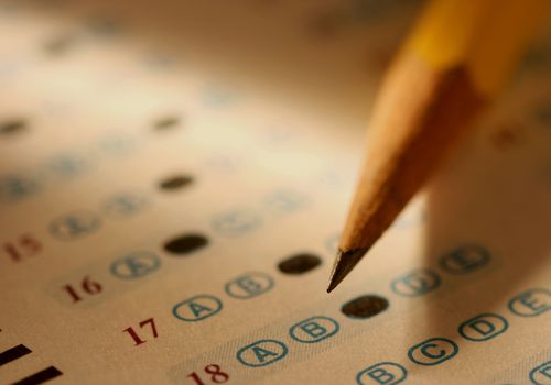 close-up of pencil marking bubbles of multiple-choice exam sheet