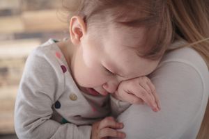 小女孩在妈妈的肩膀上哭泣