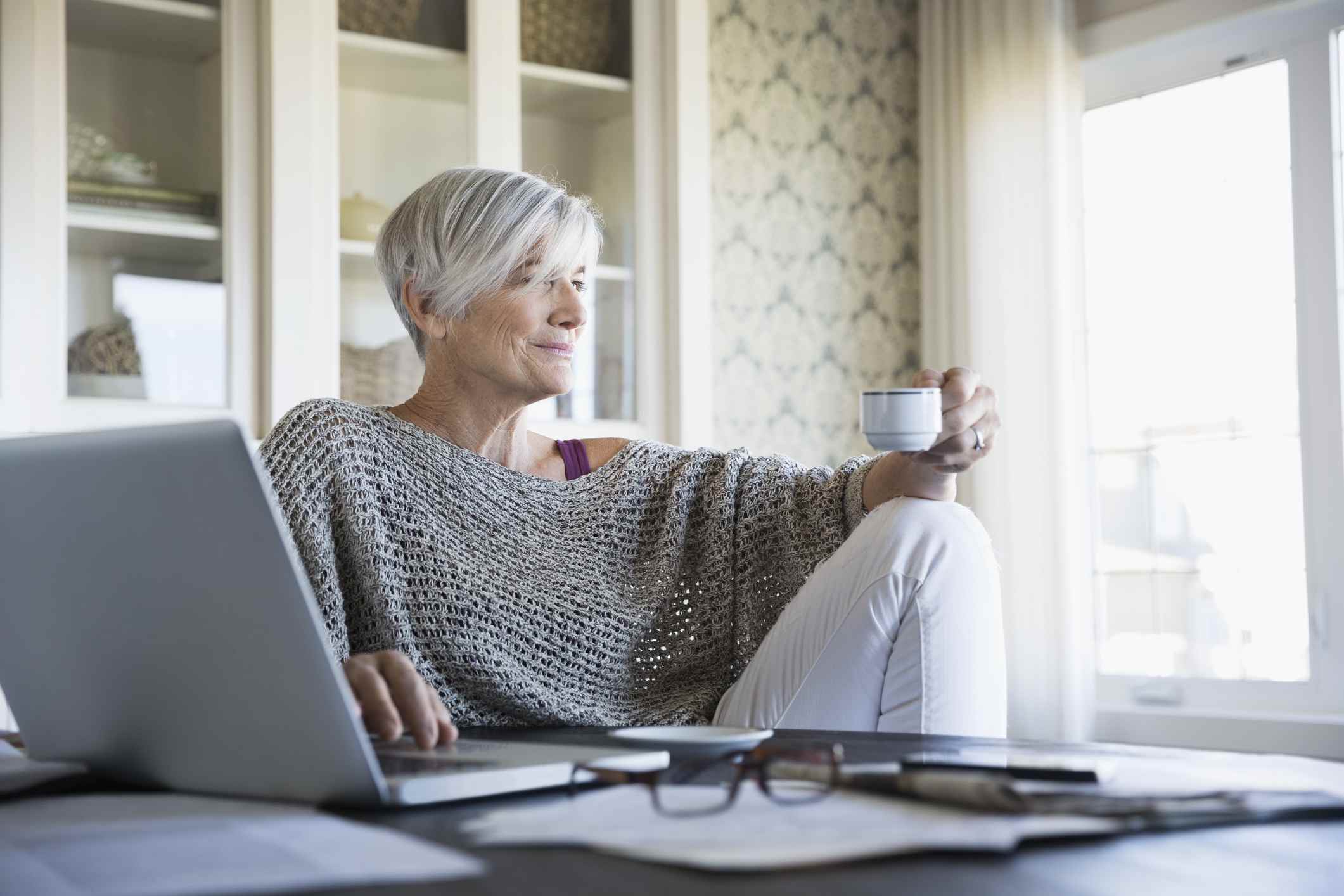 周到的高级女家庭办公望着窗外