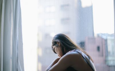 在窗口前面的哀伤的妇女