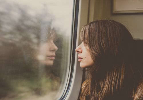 Woman looking through window in a train