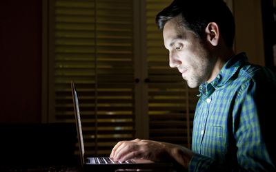 看他们的计算机的人深深在黑暗的晚上