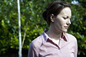 sad woman deep in thought with trees in background