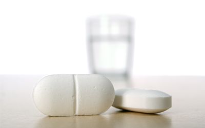 关闭与水玻璃的两个白色药片在背景中