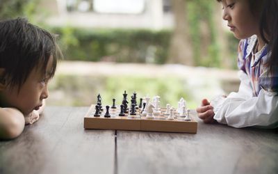 下棋的两个亚裔孩子在外面桌上