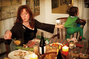 母亲在服务自我食物时抱着她的女儿