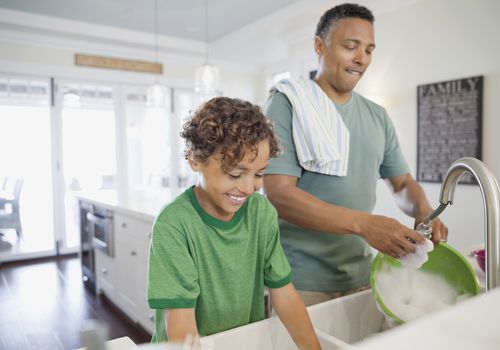 son and father doing dishes