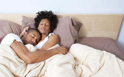 夫妻俩睡在床上，互相拥抱