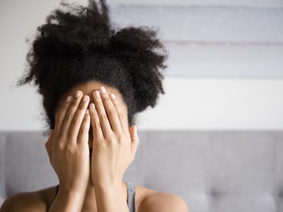 一个女人覆盖脸用手