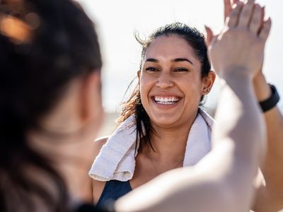 微笑的女人在锻炼后和朋友击掌