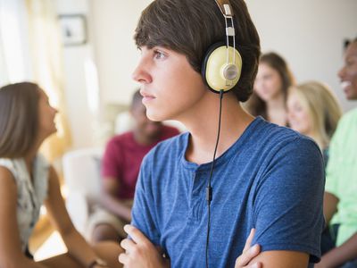 一个十几岁的男孩在派对上听耳机