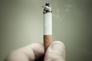 拿着燃烧着的香烟的人