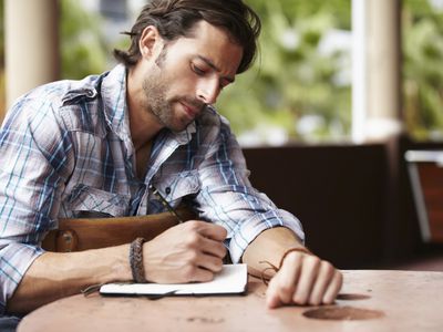 男人在笔记本上写字