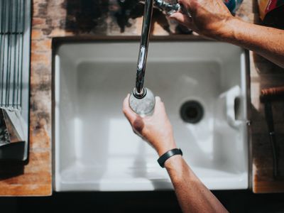 在水槽中装满水瓶的人