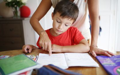 一个7岁的男孩做功课，他的妈妈