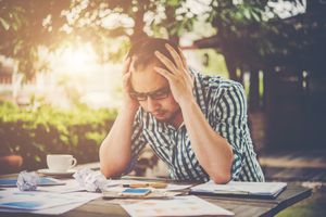 失意的年轻男子坐在办公桌头部在手