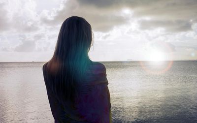 在海滩上看地平线的女人