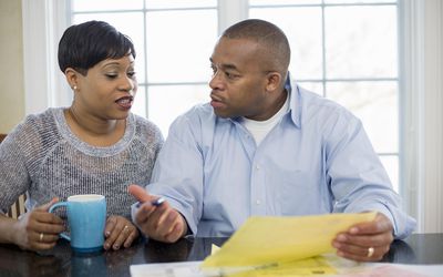Couple sitting at kitchen table discussing bills