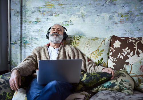 A man sitting on the couch, relaxing with headphones on