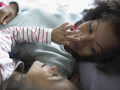 Affectionate mother and daughter cuddling, touching nose