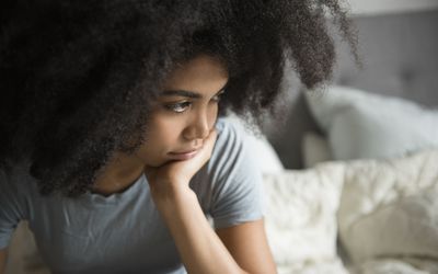 看起来在床上的妇女沮丧