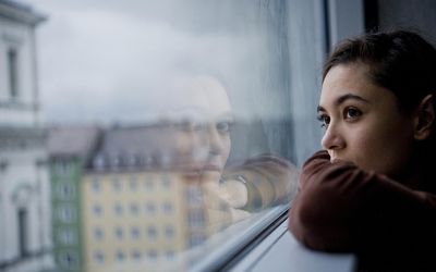 Anxious woman staring out window