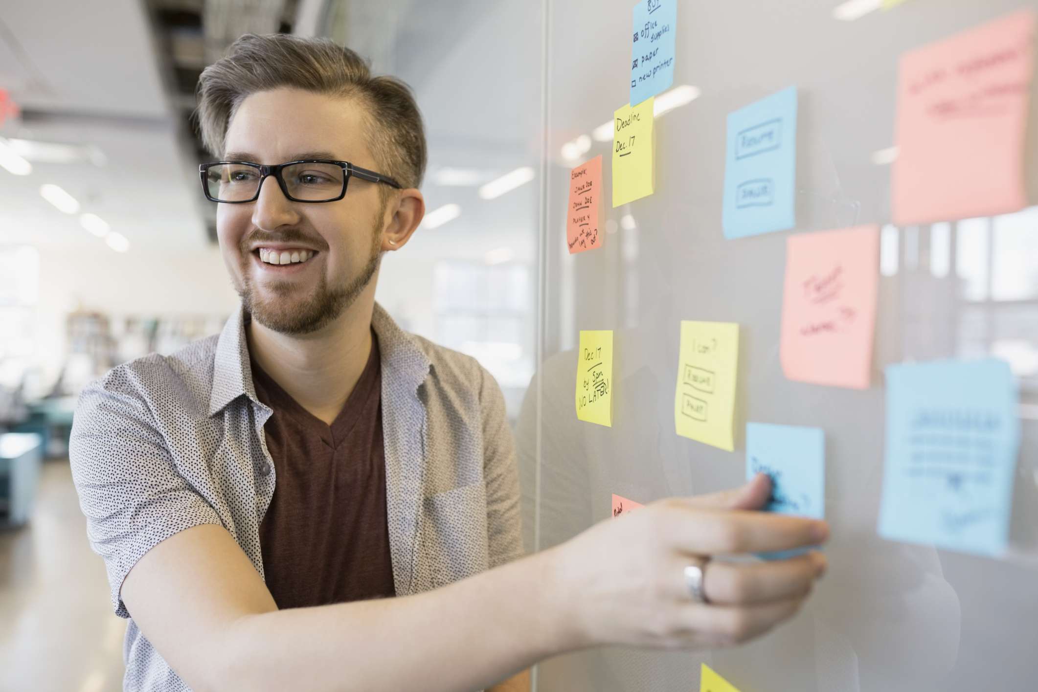 微笑的商人在白板上整理便签以帮助记忆