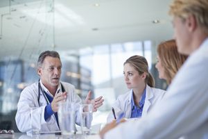 A team of doctors meets in a conference room.