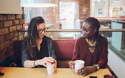Young women sitting and talking at the coffee break