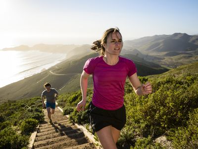 couple jogging up steps on outdoor hillside trail