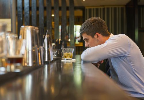 Lonely Hispanic businessman sitting at bar