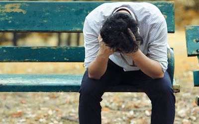 坐在长凳上的沮丧的人