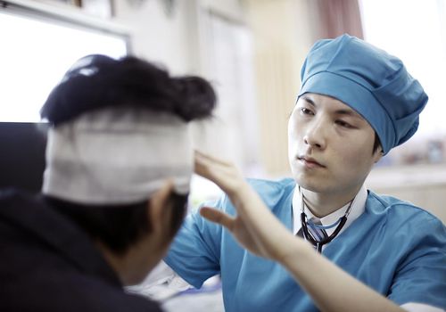 医生检查头部缠绷带的病人