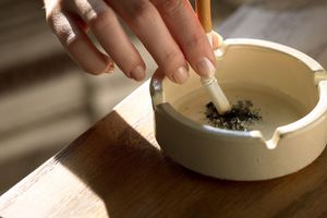 烟灰缸里手握香烟