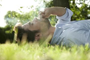 躺在草地上抽大麻的年轻人