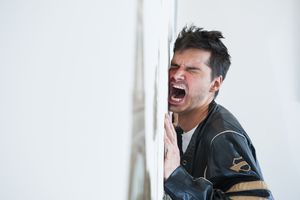 沮丧的中年男子对着墙尖叫