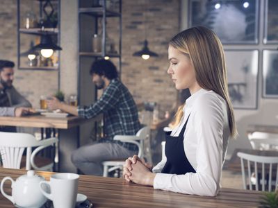 哀伤的妇女站立在酒吧