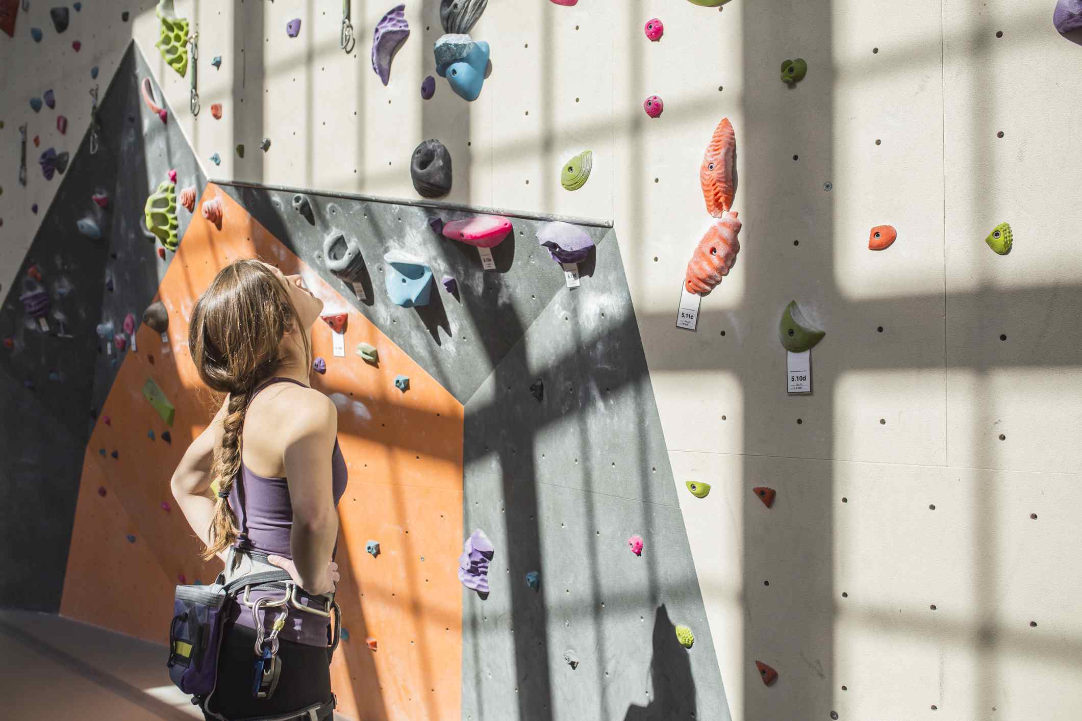 Athlete examining rock wall in gym