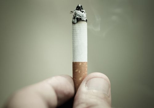 拿着灼烧的香烟的人